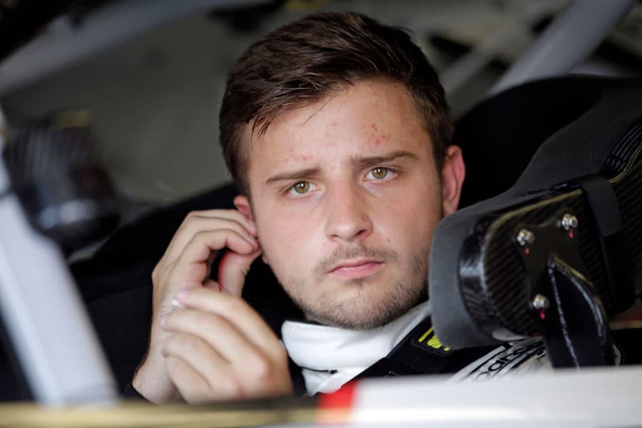 Joe Graf Jr. in race car putting ear plugs in