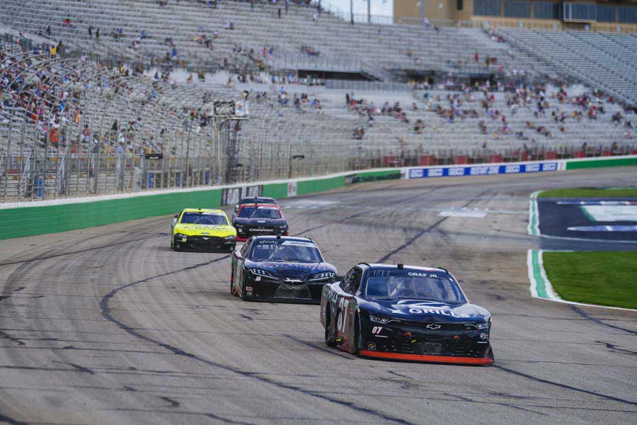 Cars racing on track with fans in stands